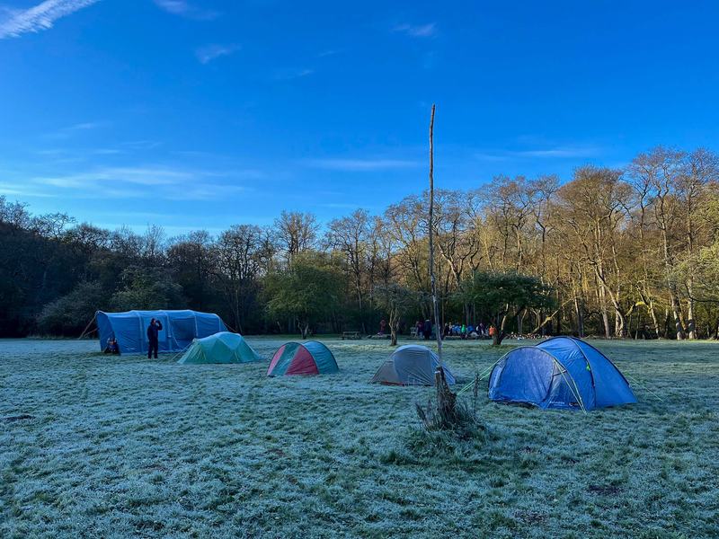 Tents on a frosty campsite field early in the morning.
